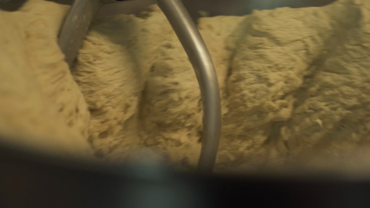 Industrial Mixer machine With wheat Dough rotating in bakery,close up