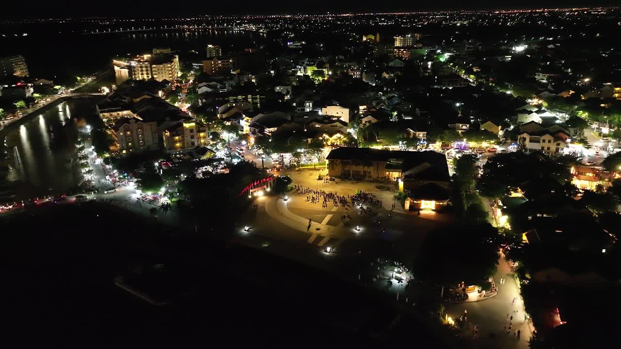 Vibrant cityscape of Hoi An, Vietnam, lit up at night with a lively atmosphere