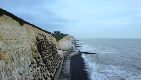 chalk cliffs on coast with sea water erosion and climate change damage