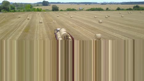 farmers harvesting straw. tractor with wagon load of hay bales