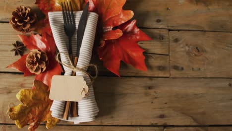 video of cutlery and autumn leaves lying on wooden surface