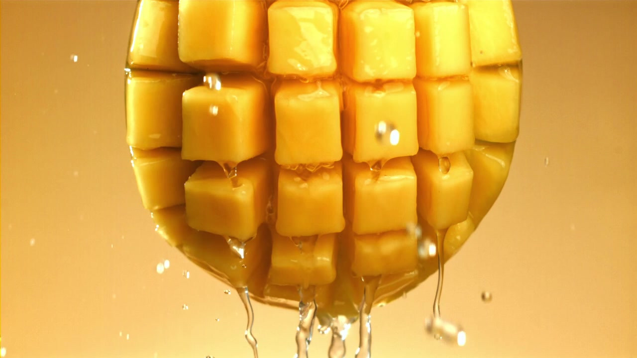 Rallentatore: Acqua che schizza su cubetti di mango succosi.
