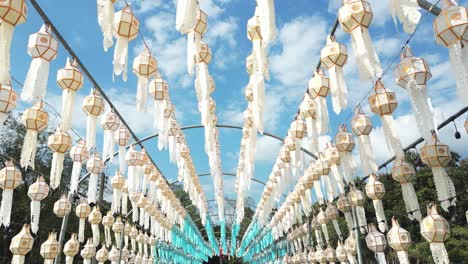 low angle drone flying through tunnel full of typical loy krathong thai lanterns