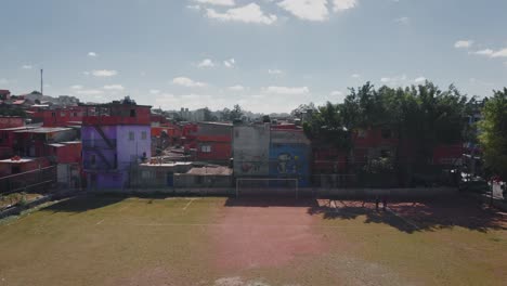 imagen aérea del paisaje del campo de fútbol de la favela - volando sobre los barrios marginales en el distrito de capão redondo, ciudad de são paulo en brasil