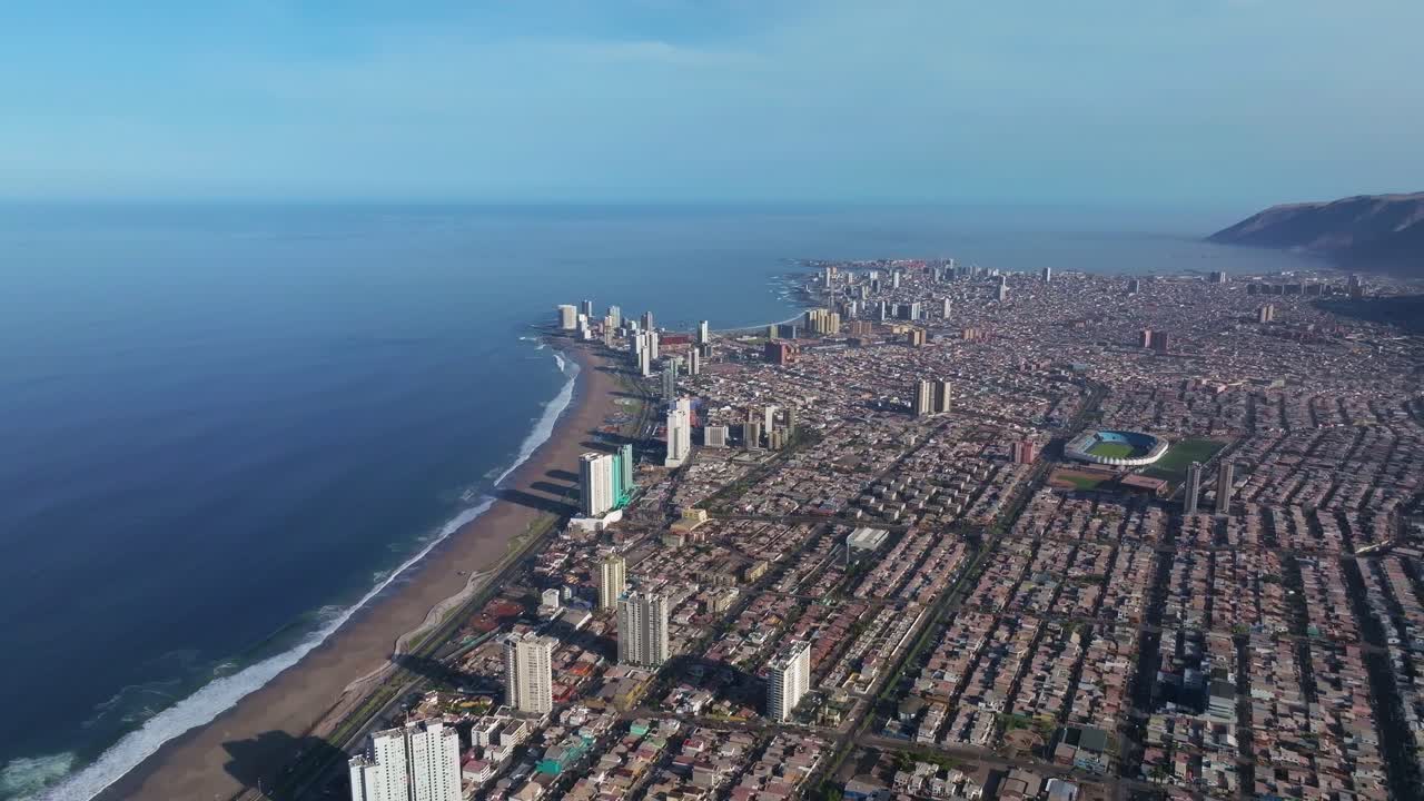 toma aérea giratoria que muestra los grandes rascacielos en el centro de iquique y la playa