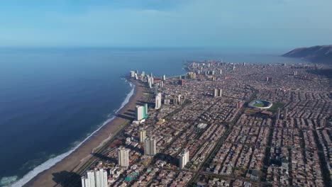 Rotierende-Luftaufnahme,-Die-Die-Großen-Wolkenkratzer-In-Der-Innenstadt-Von-Iquique-Und-Am-Strand-Zeigt