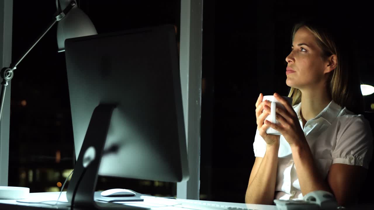 Donna d'affari che beve caffè mentre lavora al computer