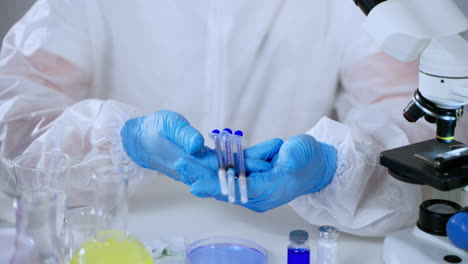 scientist holding pipettes in a laboratory setting