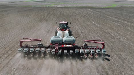 drone footage of a farmer planting corn seeds in an iowa field in a red tractordrone footage of a farmer planting corn seeds in an iowa field in a red tractor