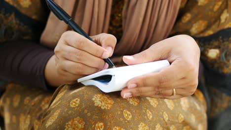 Close-up-of-women-hand-writing-on-notepad