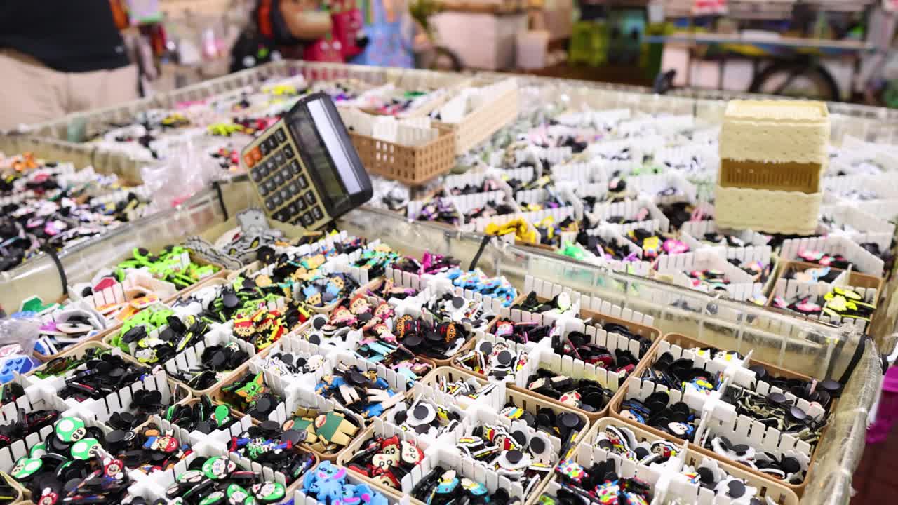 Colorful trinkets and accessories displayed on a market stall, camera smoothly panning across merchandise