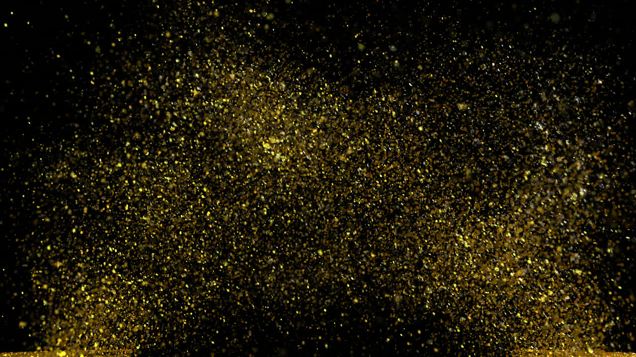 Partículas de Glitter Dourado Explodindo e Caindo sobre Fundo Preto