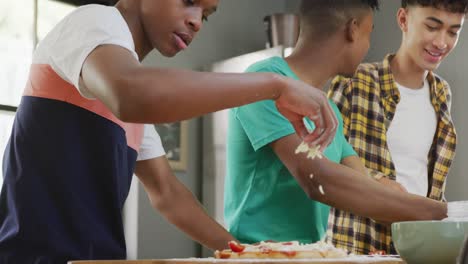 Felices-Amigos-Adolescentes-Varones-Diversos-Preparando-Pizza-En-La-Cocina,-Cámara-Lenta