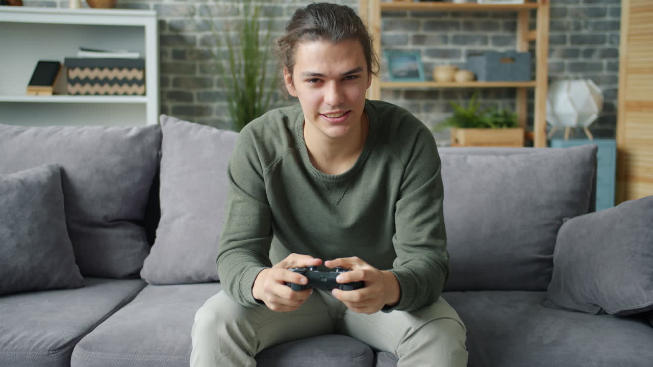 uomo che gioca a videogiochi su un divano