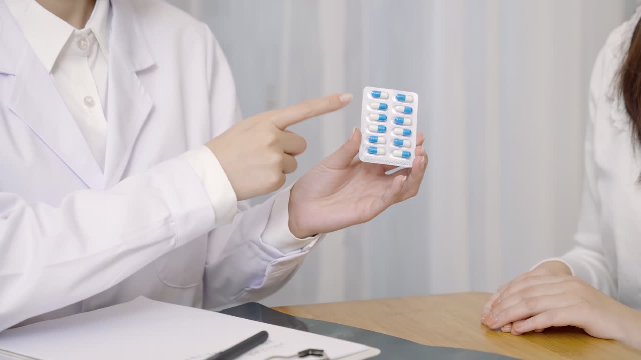 Medico professionista che spiega il trattamento, illustrando l'uso di farmaci e fornendo consigli e istruzioni dettagliate al paziente, dopo una visita e cura in ambulatorio ospedaliero.
