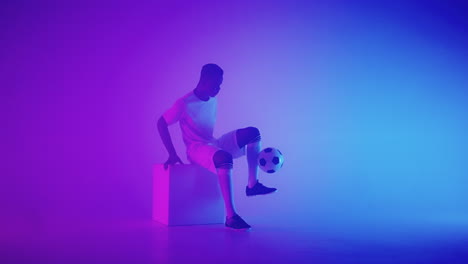 Black-african-man-Freestyle-or-professional-soccer-player-practicing-with-football-ball-juggling-on-legs-slow-motion.-Studio-shooting-of-a-professional-football-player-with-a-ball