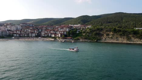 rotating drone shot of a taxi boat sailing into the black sea from the coast of bulgaria