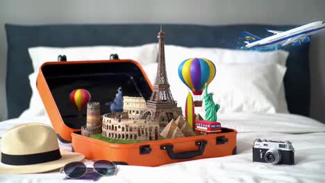 open orange suitcase on a bed with travel essentials