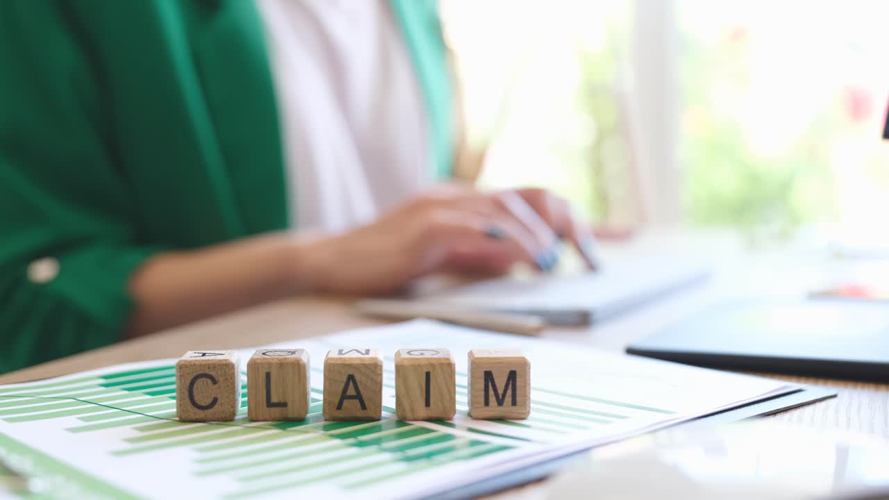 Claim text on cubes and businesswoman typing on computer keyboard