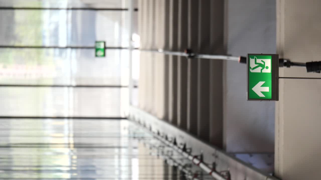 Emergency Exit Signs in a Building Corridor