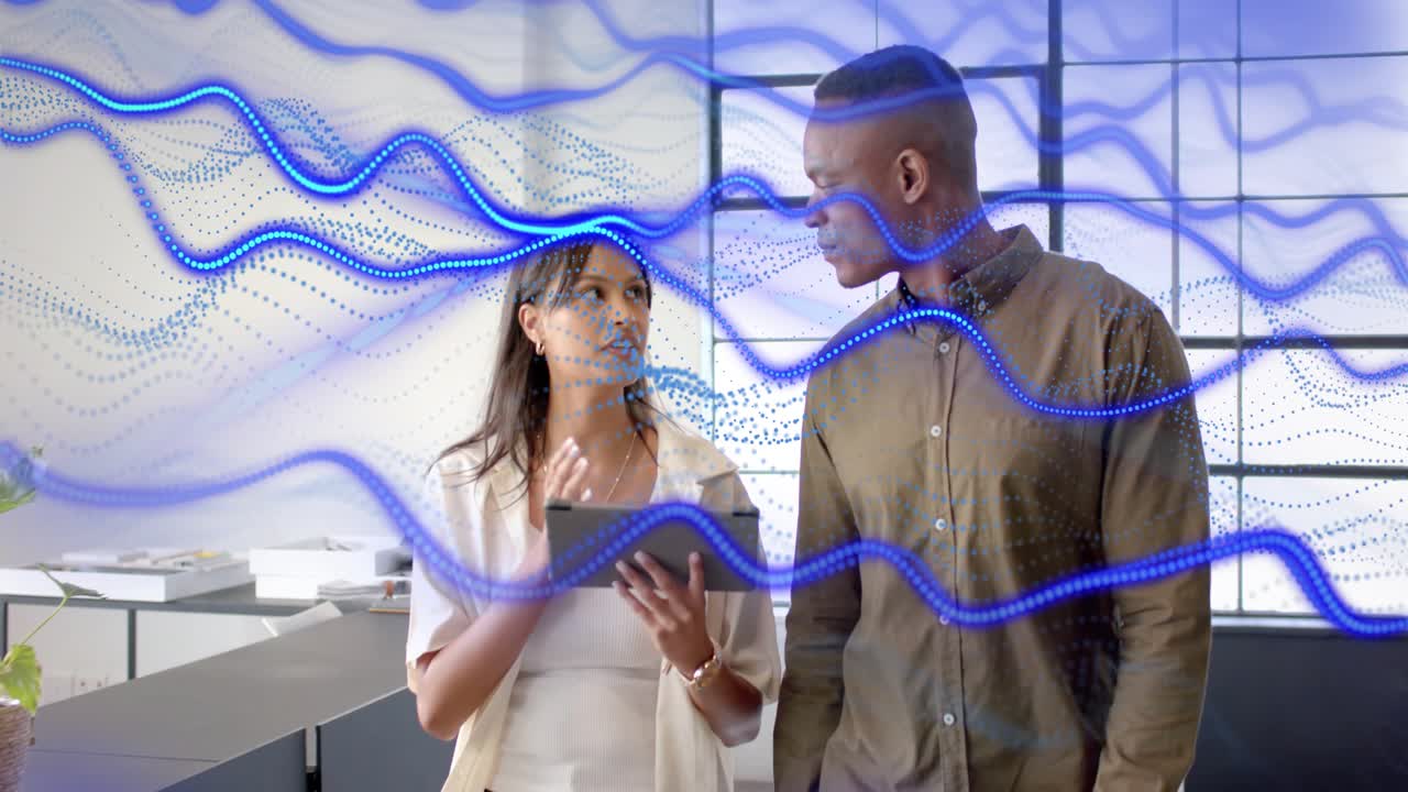 Woman tapping tablet, explaining work while walking with man, blue waves overlaying office, pausing