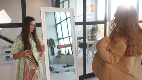 woman trying on dresses in front of mirror