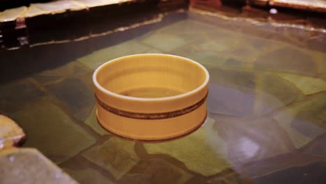 bamboo style bucket floating in japanese onsen hot spring