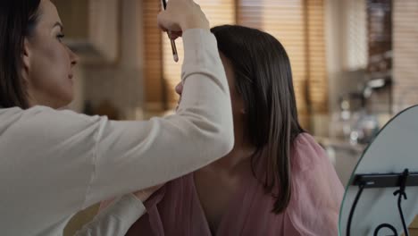 caucasian woman teaching daughter how to do make up