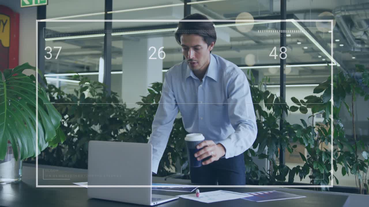 Man leaning over laptop while reviewing charts, seeing AR overlay updating for business analysis