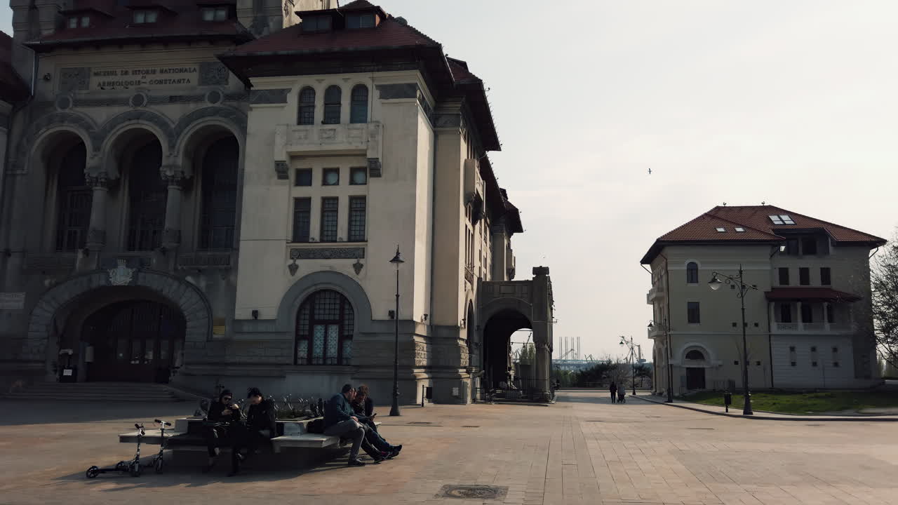 Constata, Romania - October 5, 2021: People enjoy their day near the historical building, surrounded by modern life. The architecture stands out, reflecting the city's rich history and community spirit