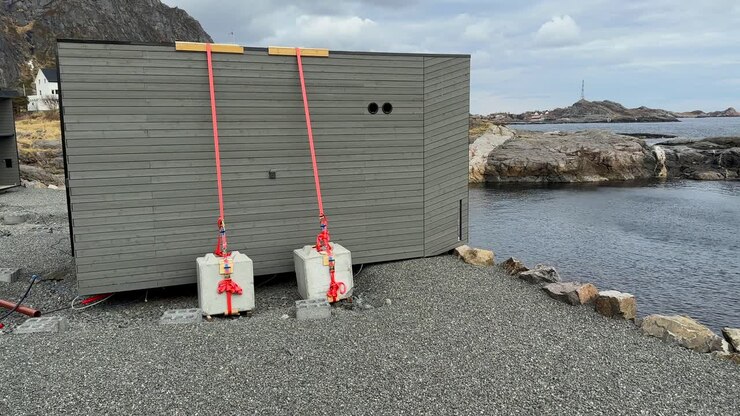 Casetta vacanza dove i turisti sono stati trascinati in mare durante una tempesta a Lofoten in A, Norvegia settentrionale, riprese a mano con panoramica
