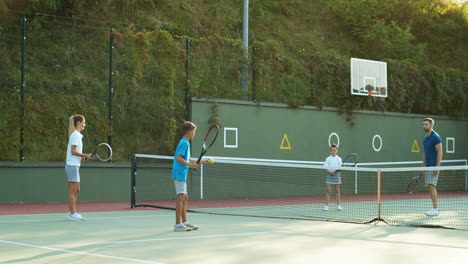 Familia-Feliz-Jugando-Tenis-En-Una-Cancha-Al-Aire-Libre-En-Verano-3