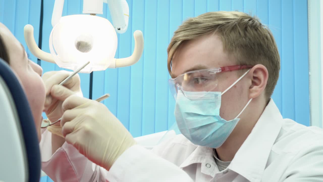 стоматолог осматривает пациента