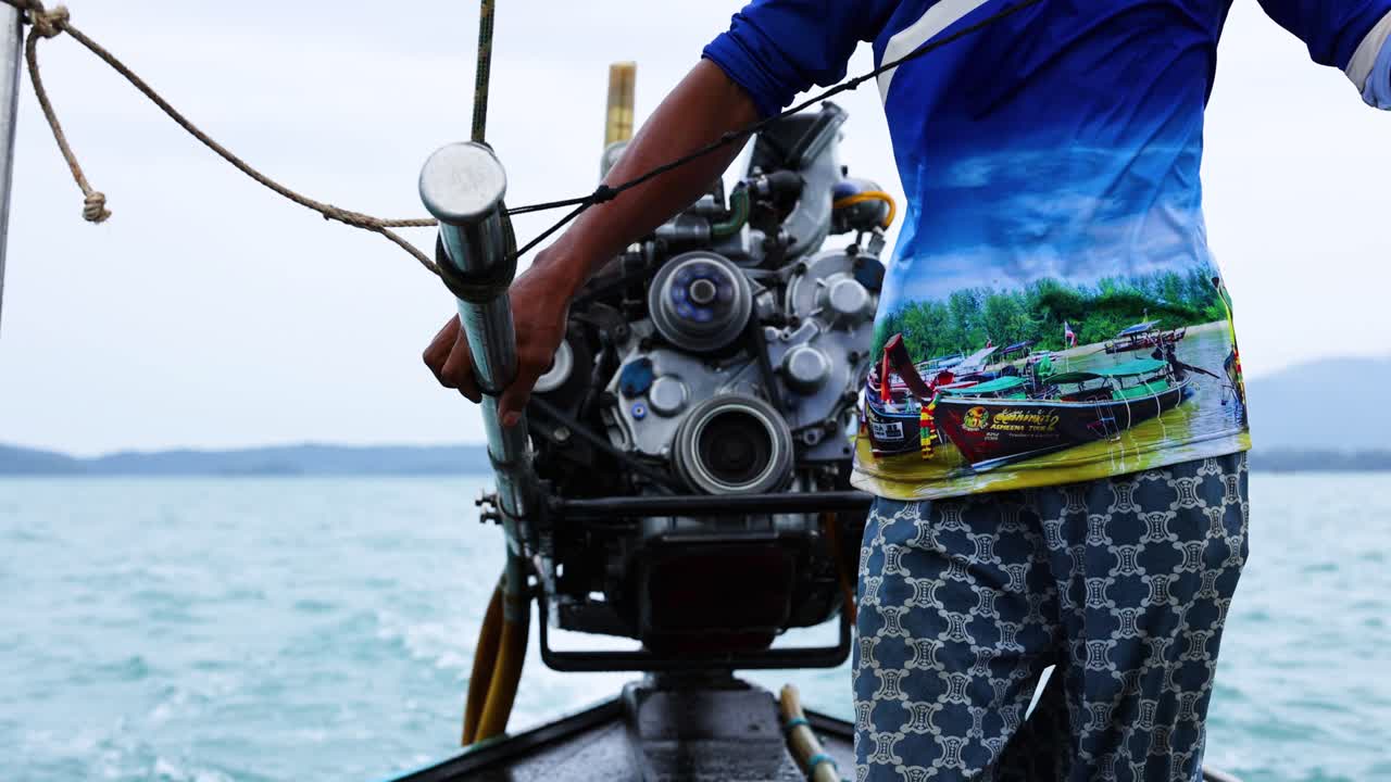 Man steering boat engine in scenic Krabi waters