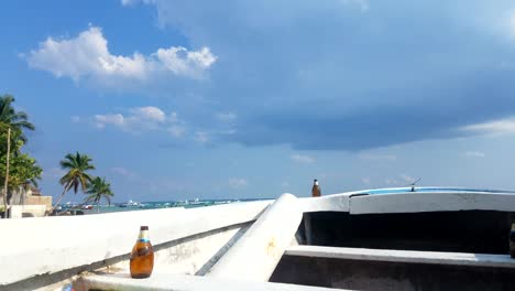 Timelapse-De-Video-De-La-Playa-Y-El-Barco-Con-Una-Cerveza-Y-Nubes-Lentas-Que-Pasan-En-Un-Hermoso-Día-Soleado-Cerca-De-Cancún,-México