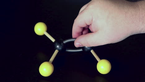 ball and stick model of ethene with a double bond being moved around on a black lab bench