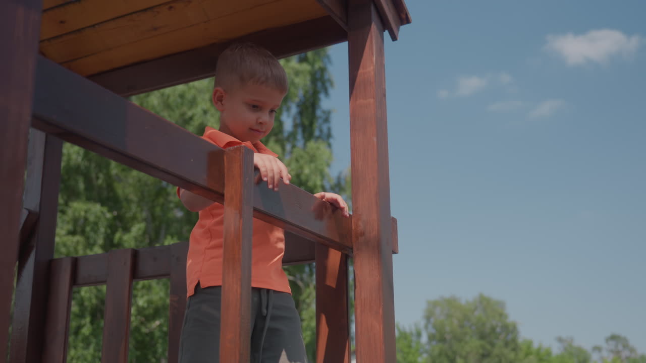 Child Climbing Slide, Child With Fair Skin Engages In Play On Outdoor Equipment, Young Caucasian Boy Concentrates Intensely While Navigating Playground Climbing Structures Under Summer Sky