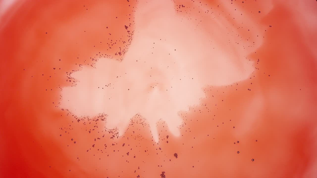 작은 투명한 회색 거품이 은 액체의 중심으로 이동합니다.