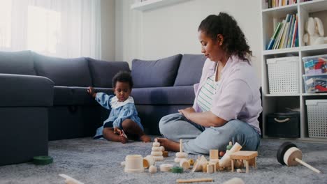 madre e hija jugando con juguetes de madera