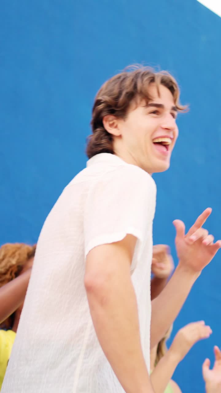 Man dancing with multiracial happy friends in an urban space