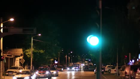 Cars-stopping-at-a-stop-sign-waiting-to-turn-green-so-they-can-pass