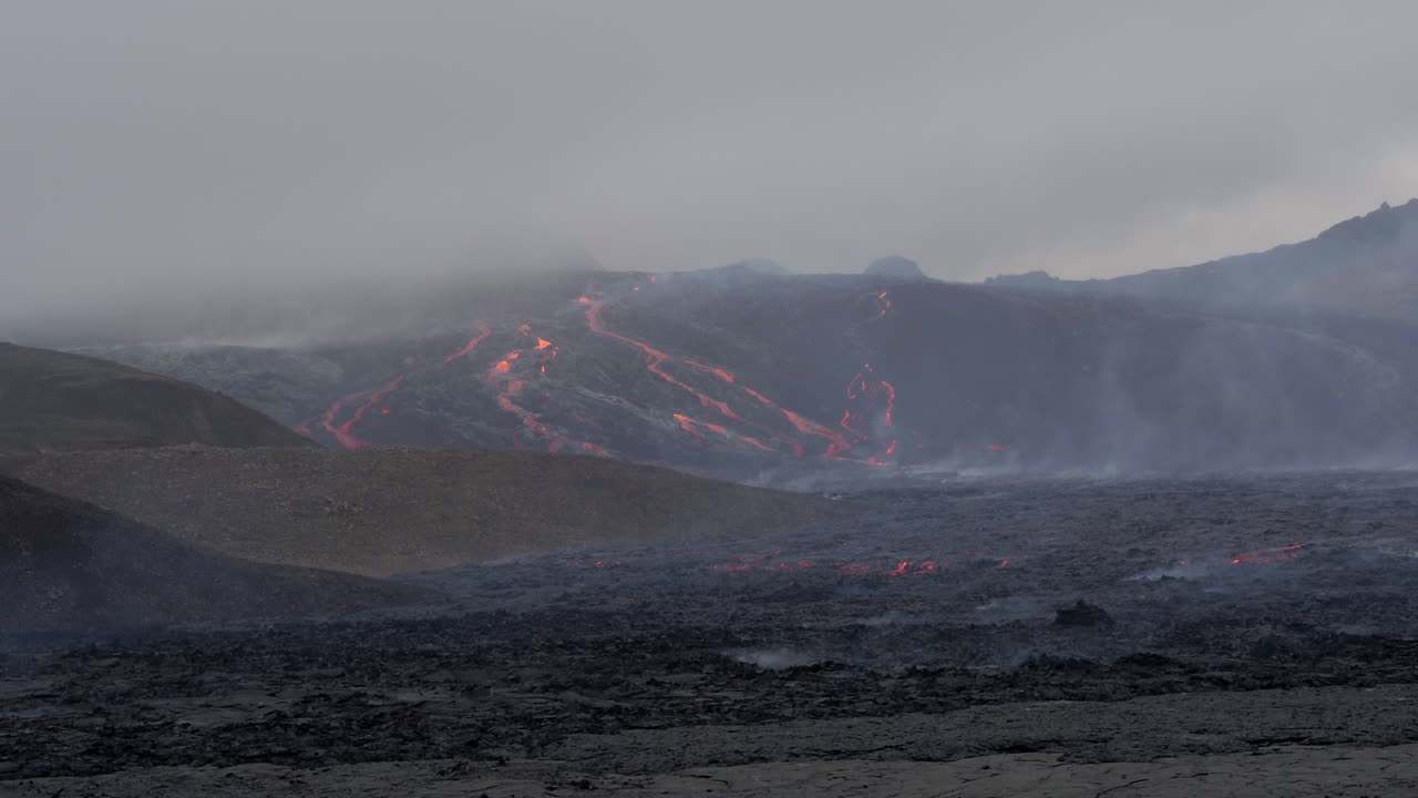 Fagradalsfjall volcano in Iceland low aerial push in shot over the cooling lava towards the lava river