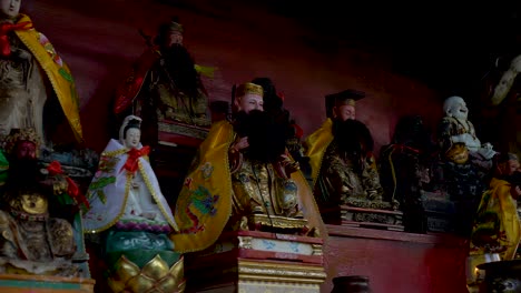 Slow-motion-landscape-shot-of-Buddhist-Buddha-statue-shrine-altar-monument-in-front-of-home-Singapore-city-Asia-religion-spirituality-sacred-culture