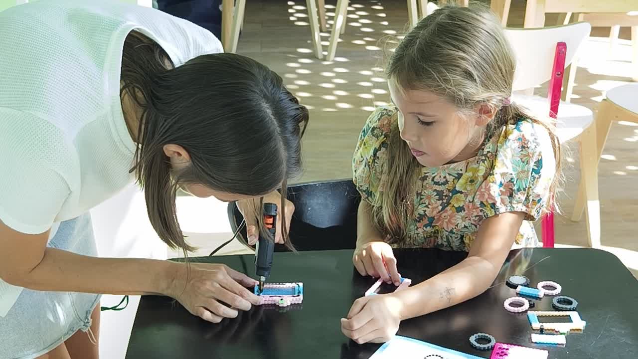 madre e hija haciendo artesanía juntos
