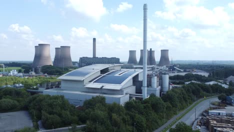 clean solar rooftop installation on modern office building aerial view with coal power station in background descending shot