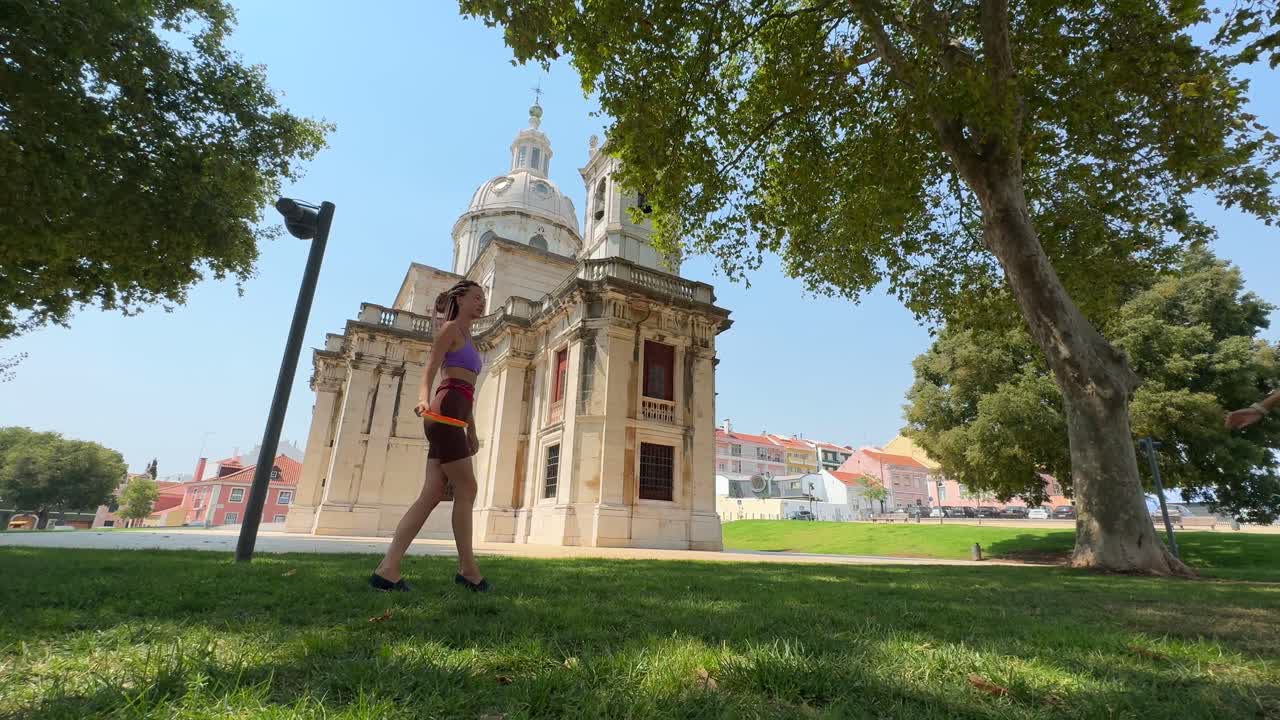 Woman playing frisbee in front of a church