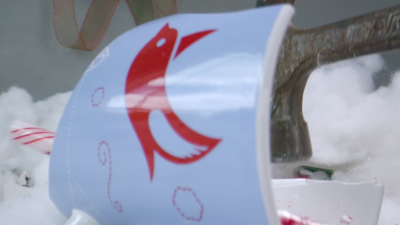 망치로 박살나는 크리스마스 컵의 슬로우 모션 샷