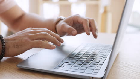 Hands-typing-email-on-laptop-at-desk-in-house