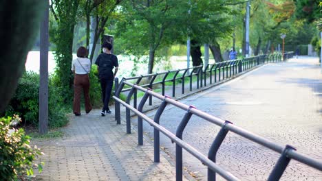 An-Sommertagen-In-Tokio-Nutzen-Paare-Die-Kühle-Des-Nachmittags,-Um-In-Den-Freiluftparks-Spazieren-Zu-Gehen-Und-So-Neben-Dem-Rauschen-Der-Natur-Einen-Ruhigen-Moment-Verbringen-Zu-Können