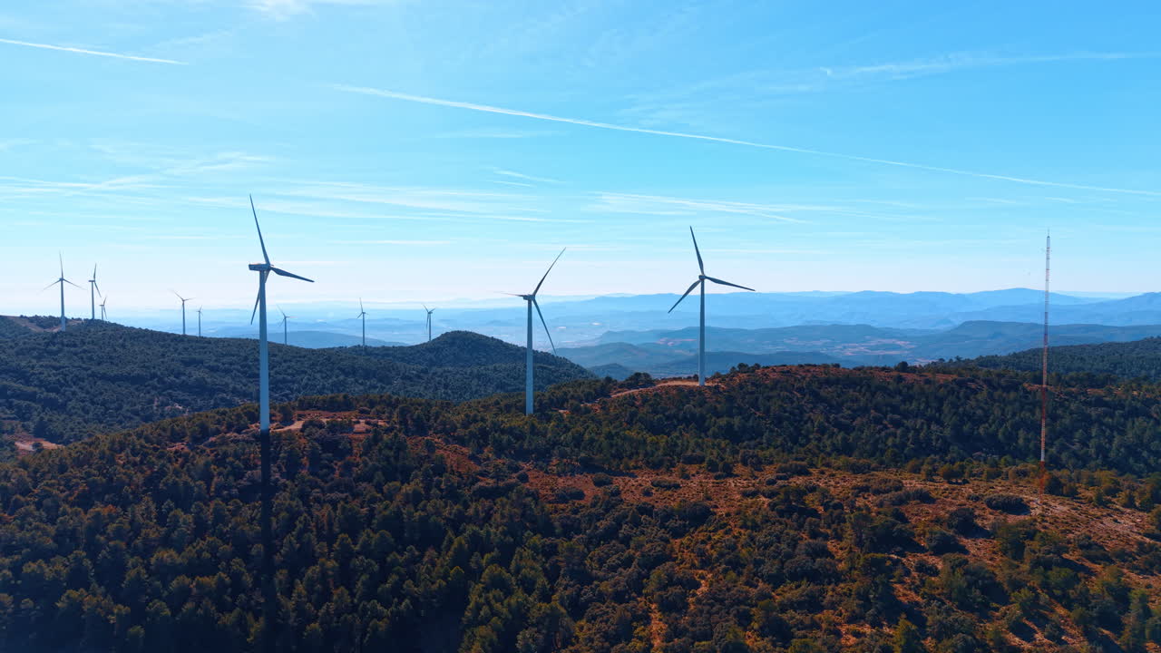 Alicante, Spagna, 8 agosto 2025: Ampia veduta aerea di un parco eolico sulle colline spagnole. Molteplici turbine eoliche che generano energia rinnovabile su catene montuose boscose in Spagna
